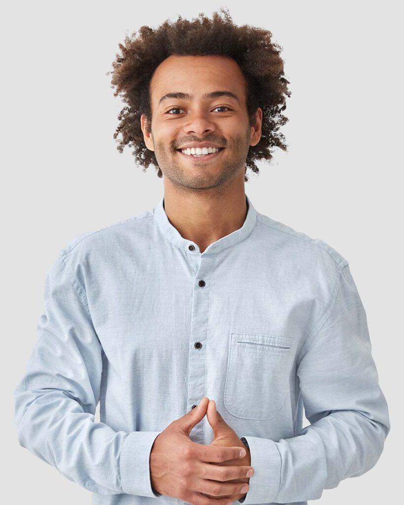 Een lichtgetinte student met een blauwe bloes glimlacht tijdens de opleiding Praktijkmanagement Huisartsenzorg van Sitis.